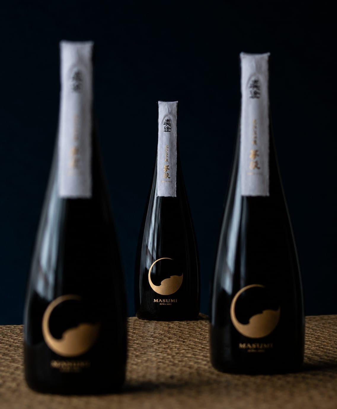 Bouteilles de saké Masumi aux cols enveloppés de papier, logo doré en forme de lune